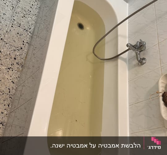 אמבטיה עם מים צהובים וברז מתכת